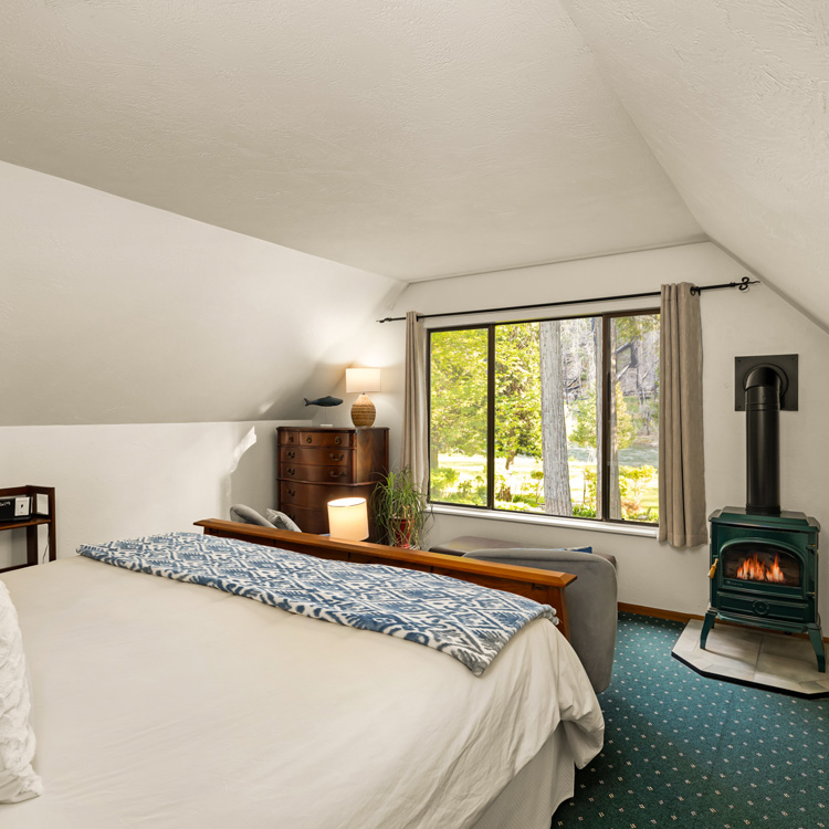 Beautiful wood king bed with gas stove overlooking the garden and McKenzie river.