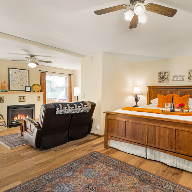 Beautiful wood king bed with match nightstands. Leather couch in front of gas fireplace.